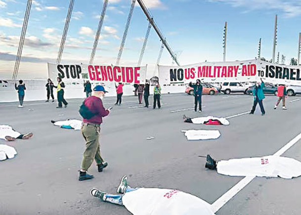示威者用白床單覆蓋身體躺在路上。