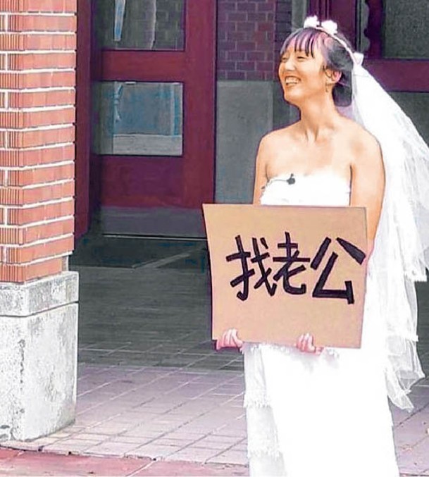 女生穿婚紗站在台灣大學圖書館門前徵婚。