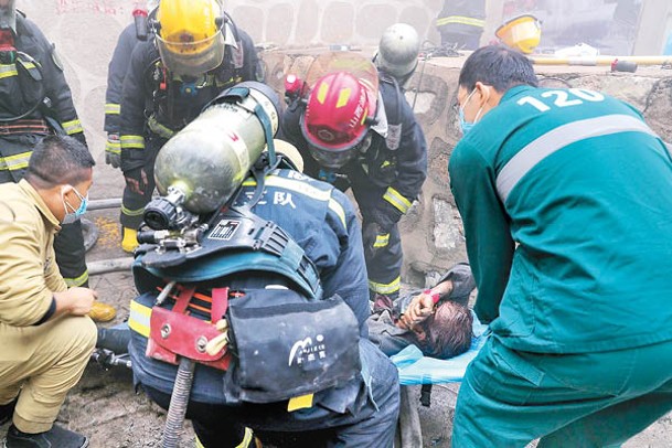 消防員在災場救出傷者。