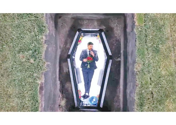 唐納森躺在透明棺材裏。