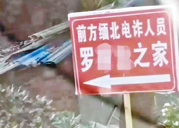 村道旁的牌子寫有「前方緬北電詐人員羅××之家」。