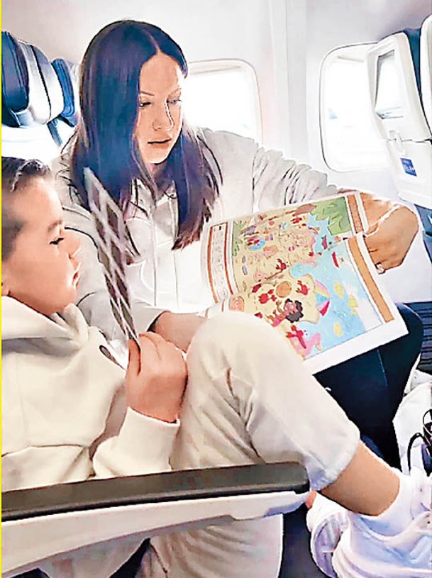 羅伯茨（右）在飛機上照顧孩子。