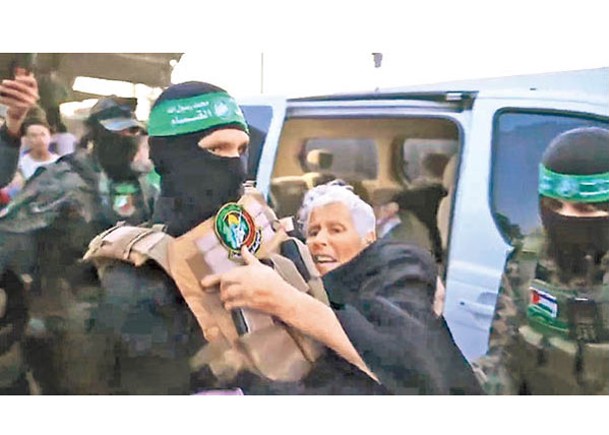 哈馬斯武裝分子抱起一名年長的以色列人質。