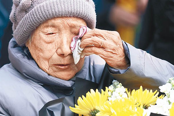 有老人在儀式上拭淚。（中新社圖片）
