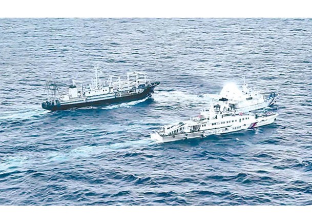 中國海警船（下）發射水炮阻止菲律賓船隻（中）駛近仁愛礁。