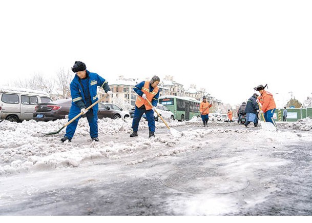河南工人剷走路面積雪。（中新社圖片）