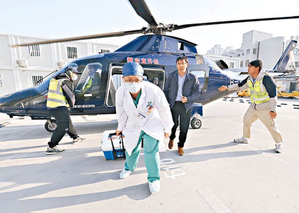 內地醫護人員從直升機搬運器官至手術室。（中新社圖片）