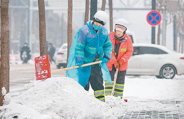 北京清潔工人在街頭清掃積雪。（中新社圖片）