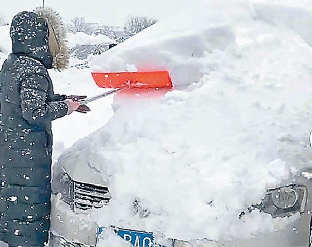 山東：威海市民清理車身積雪。