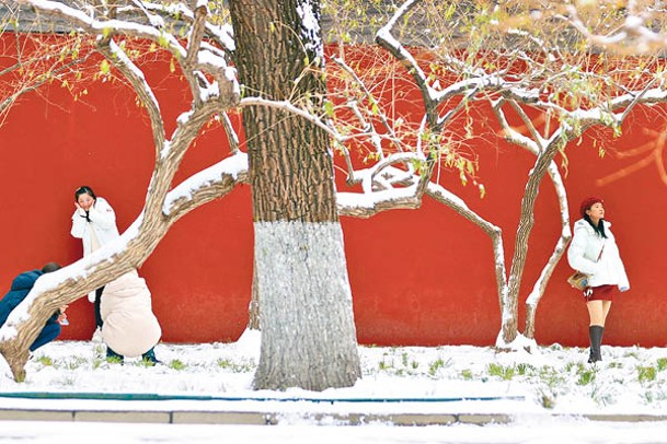 北京民眾在雪地上拍照賞雪。（中新社圖片）