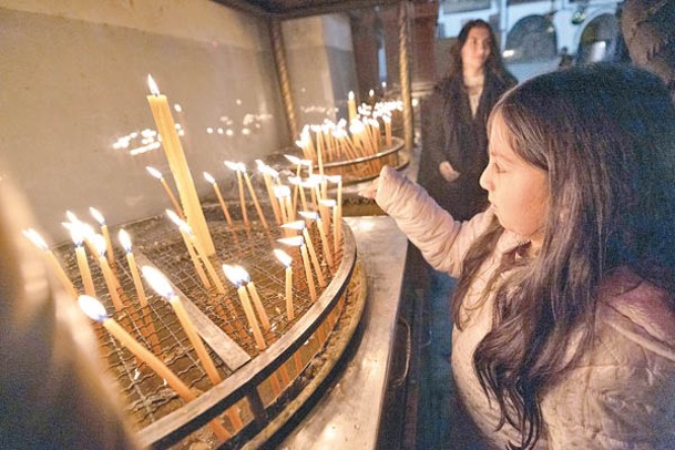 伯利恆一名女孩在教堂燃點燭光。
