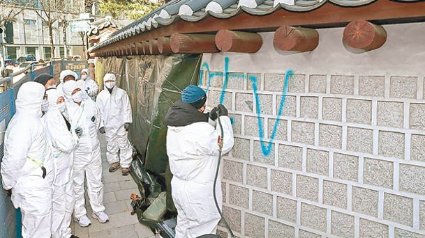 工作人員清理景福宮外牆塗鴉。