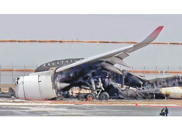 日航客機嚴重焚毀，殘骸仍在跑道上未移走。