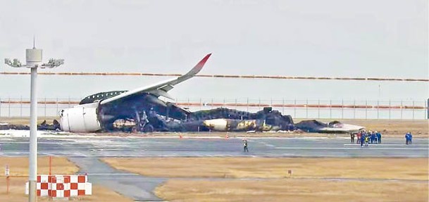 日航客機殘骸在跑道上。