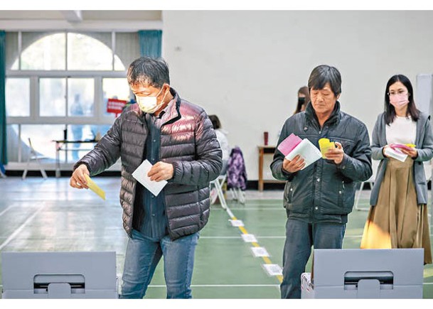 在台南市一個票站內，選民排隊投票。