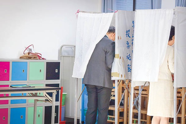 民眾黨柯文哲（左）與太太（右）在台北市一個票站投票。