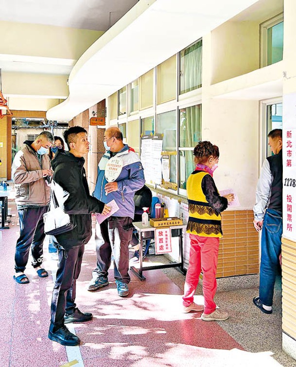 台灣民眾在新北市一間小學內設置的投票所排隊投票。（中新社圖片）