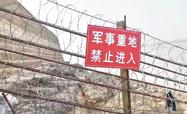 鐵絲網欄杆掛着寫上「軍事重地，禁止進入」的警告牌。