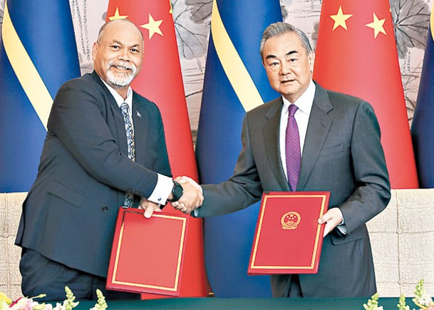 王毅（右）與安格明（左）簽署聯合公報。（中新社圖片）