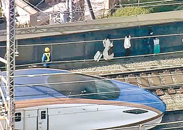 工作人員協助乘客離開停駛列車。