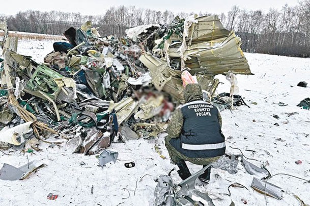 俄羅斯調查人員檢視運輸機殘骸。