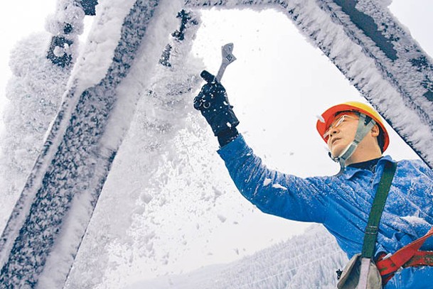 重慶：有工人清理電纜的積雪。
