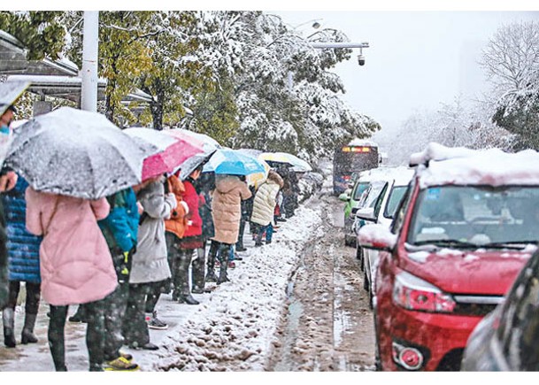 安徽：合肥民眾外出打傘擋雪。