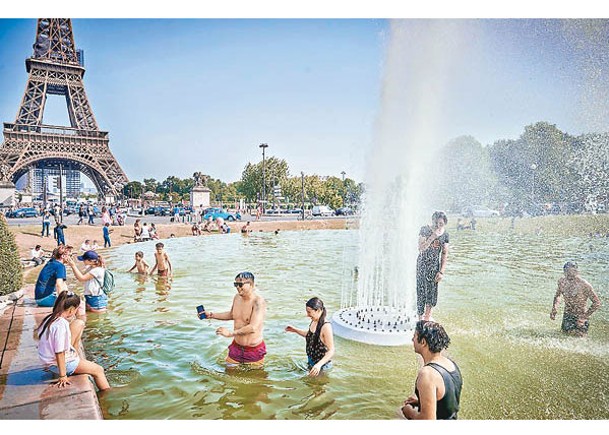 民眾在巴黎艾菲爾鐵塔前戲水消暑。（Getty Images圖片）