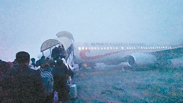 黑龍江：乘客冒着大霧在哈爾濱的機場登機。