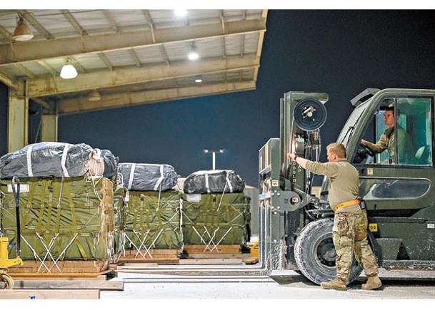 美國空軍人員搬運放有援助物資的卡板。