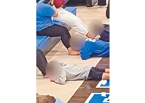 學生趴在地板上舔舐同學腳趾上的花生醬。