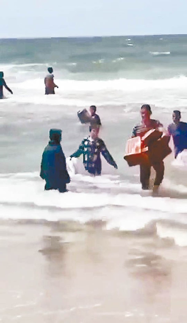 巴勒斯坦人從海中撈起空投救援物資。