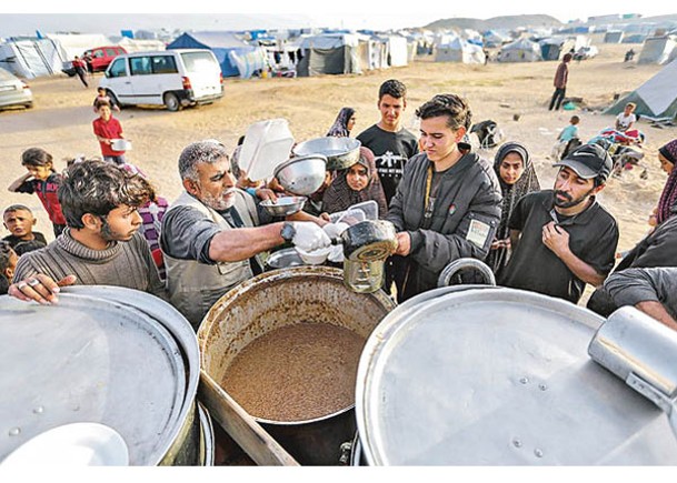 在拉法避難的巴勒斯坦人領取食物。（Getty Images圖片）