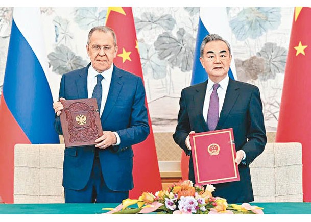 拉夫羅夫（左）與王毅（右）在會談後簽署文件。