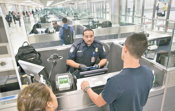 美國海關及邊防局人員在華盛頓杜勒斯國際機場檢查入境旅客資料。