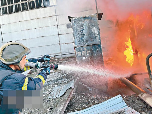 烏克蘭消防員向遭俄羅斯空襲起火的發電廠射水。