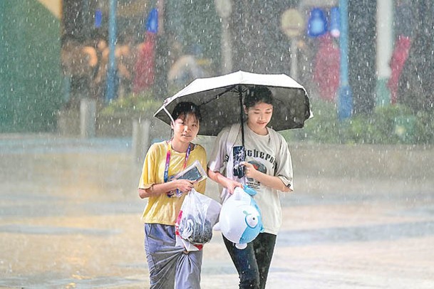 廣州市民冒雨出行。（中新社圖片）