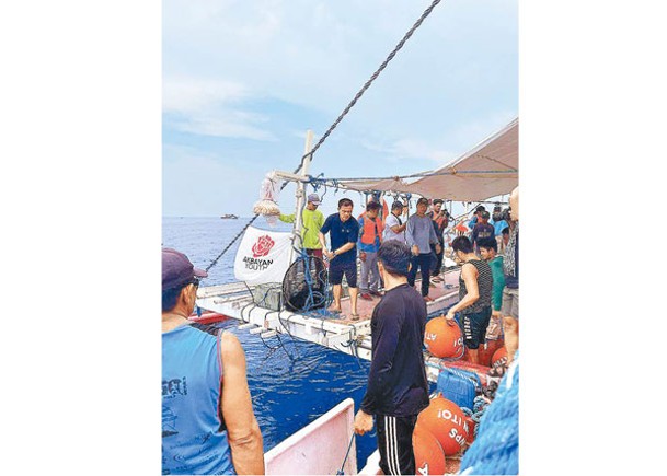 菲方船隻向漁民發放補給品。