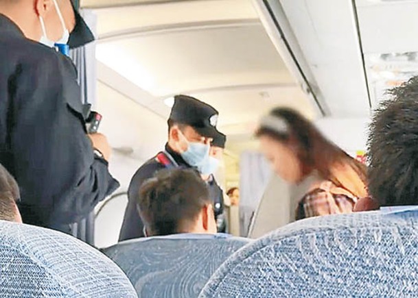 女乘客（右）在飛機上吸電子煙被帶走。