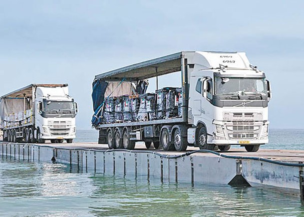 運送人道物資的貨車通過加薩臨時碼頭。