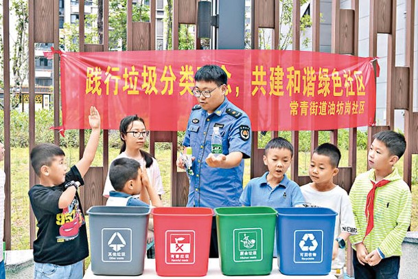 人員向兒童講授垃圾分類知識。
