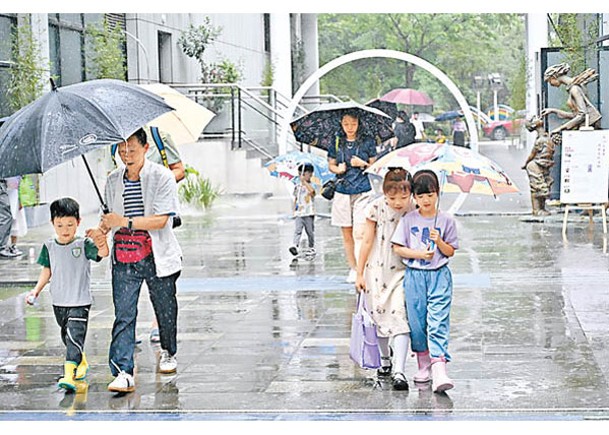 「馬力斯」登陸廣東省沿海地區，廣州市民在雨中出行。（中新社圖片）