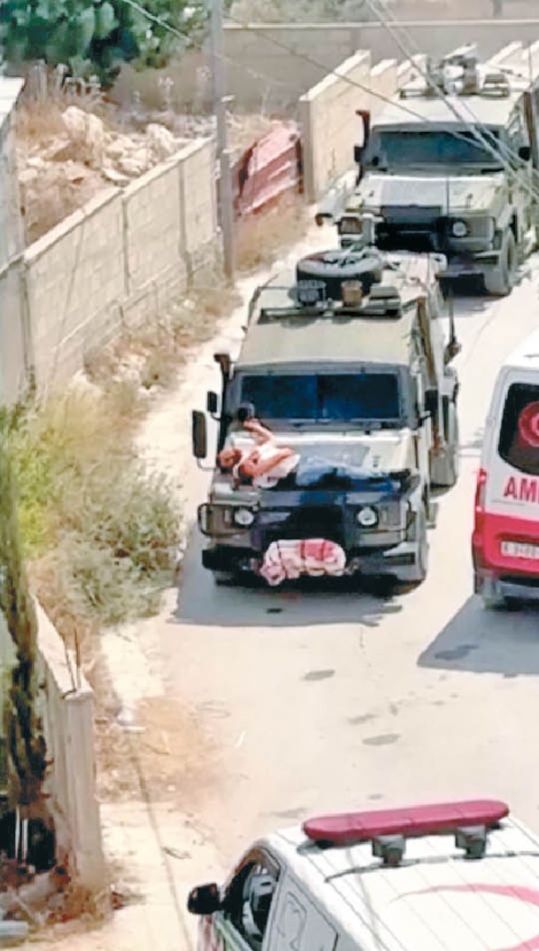 影片中，一名巴勒斯坦男子被綁在吉普車車頭蓋上。
