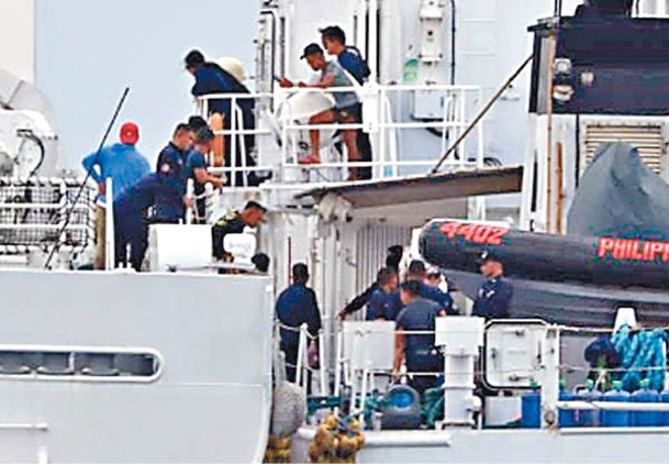 人員搬運物資過船。