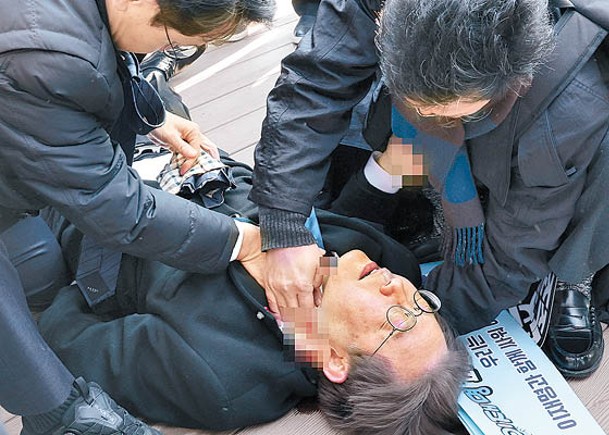 李在明（躺地者）在釜山遭兇徒持刀襲擊。（Getty Images圖片）
