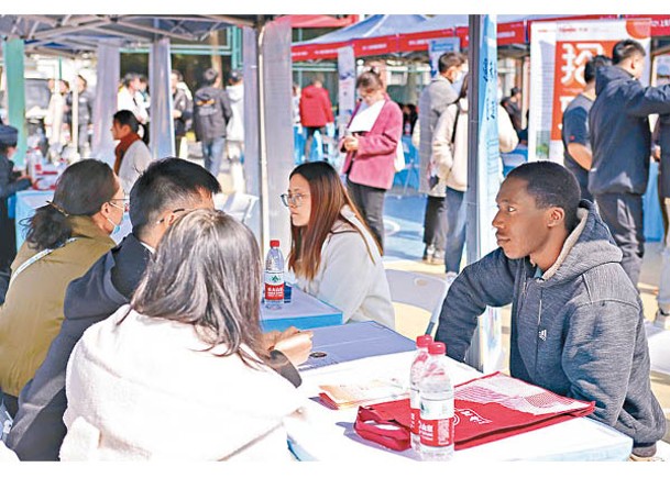 上海理工大學外籍留學生（右一）與招聘單位工作人員進行交流。（中新社圖片）