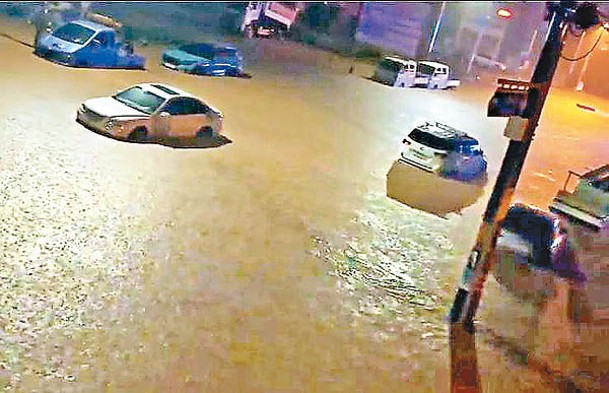 南韓連場暴雨，汽車涉水而行。