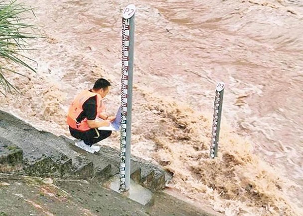 重慶有監測員量度河流水位。