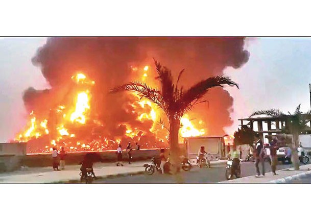 荷台達港口遭轟炸後陷火海。