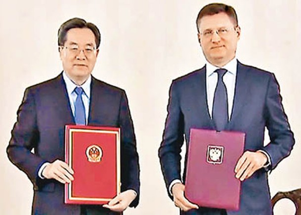 會後丁薛祥（左）與諾瓦克（右）簽署會議紀要。
